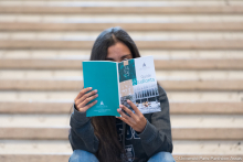 Photo d'un étudiant qui lit le guide étudiant à l'université